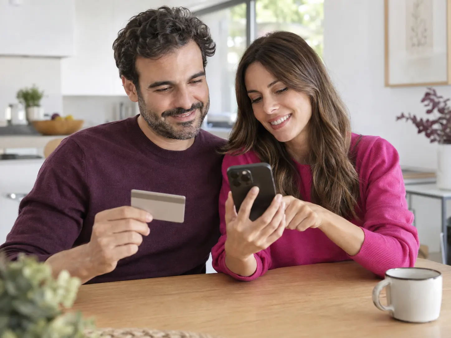 Una pareja realiza el pago de la cuota desde su teléfono